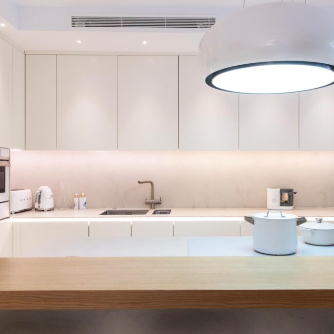 Cocina estilo nórdico con barra en madera y muebles blancos | KUBIC