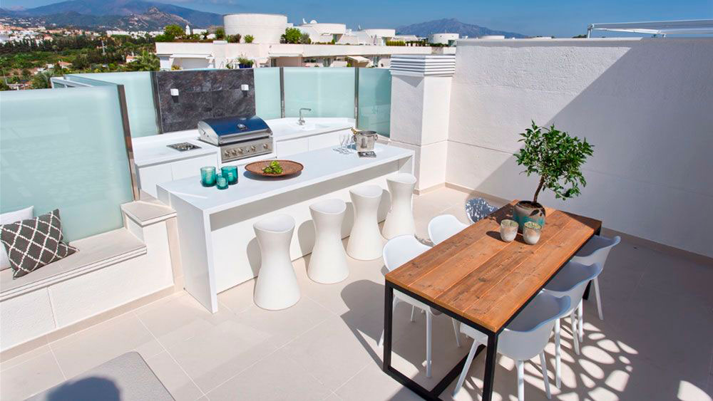Cocina exterior con barra y asientos en la Costa del Sol | Kubic Design Solutions
